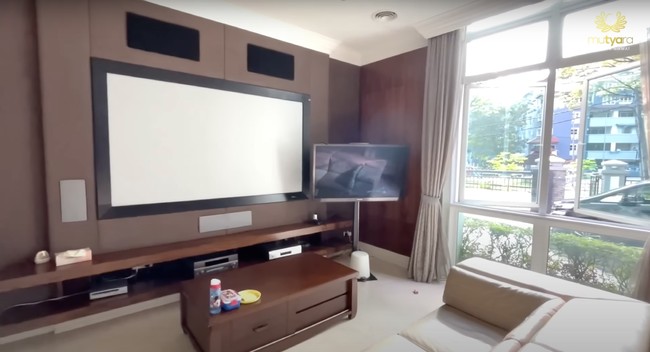 Rumah mewah milik Tya dan suaminya juga dilengkapi dengan fasilitas beragam, salah satunya bioskop pribadi. Terdapat layar proyektor, televisi, speaker, serta sofa yang cukup nyaman uuntuk dipakai selama menonton. Foto: YouTube/THE TYAS FAMILY