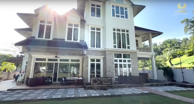 Begini penampakan bagian belakang rumah. Terdapat kursi-kursi untuk bersantai serta halaman yang ditumbuhi oleh rumput hijau yang membuat hunian semakin terasa asri. Foto: YouTube/THE TYAS FAMILY
