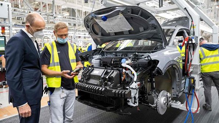 The manager of the Volkswagen production site in Emden Uwe Schwartz (L) and the CEO of the Volkswagen Passenger Cars brand Ralf Brandstaetter (R) pose near a Volkswagen (VW) ID.4 electric car at the assembly line of German carmaker Volkswagen in the production site in Emden, northern Germany, on May 20, 2022. (Photo by DAVID HECKER / AFP) (Photo by DAVID HECKER/AFP via Getty Images)