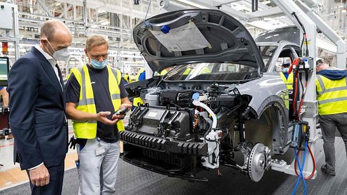 Volkswagen Kebut Produksi 800 Ribu Mobil Listrik Selama 2022 The manager of the Volkswagen production site in Emden Uwe Schwartz (L) and the CEO of the Volkswagen Passenger Cars brand Ralf Brandstaetter (R) pose near a Volkswagen (VW) ID.4 electric car at the assembly line of German carmaker Volkswagen in the production site in Emden, northern Germany, on May 20, 2022. (Photo by DAVID HECKER / AFP) (Photo by DAVID HECKER/AFP via Getty Images)