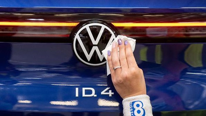 The manager of the Volkswagen production site in Emden Uwe Schwartz (L) and the CEO of the Volkswagen Passenger Cars brand Ralf Brandstaetter (R) pose near a Volkswagen (VW) ID.4 electric car at the assembly line of German carmaker Volkswagen in the production site in Emden, northern Germany, on May 20, 2022. (Photo by DAVID HECKER / AFP) (Photo by DAVID HECKER/AFP via Getty Images)