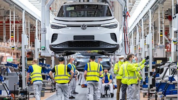 Volkswagen Kebut Produksi 800 Ribu Mobil Listrik Selama 2022 The manager of the Volkswagen production site in Emden Uwe Schwartz (L) and the CEO of the Volkswagen Passenger Cars brand Ralf Brandstaetter (R) pose near a Volkswagen (VW) ID.4 electric car at the assembly line of German carmaker Volkswagen in the production site in Emden, northern Germany, on May 20, 2022. (Photo by DAVID HECKER / AFP) (Photo by DAVID HECKER/AFP via Getty Images)