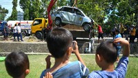 Petugas mengangkat mobil yang terperosok ke dalam selokan di jl Pangeran Hidayat, di Kota Gorontalo, Gorontalo, Senin (23/5/2022).