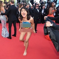 Seorang wanita bikin ulah di karpet merah festival film Cannes. Dia tiba-tiba masuk ke karpet merah dan tidak mengenakan busana. Aksinya tersebut jadi heboh dan pusat perhatian. Foto: Getty Images