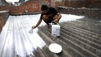 Warga mengecat atap rumah dengan cat reflektif putih dingin di Ahmedabad, India, Senin (23/5/2022) waktu setempat. Usaha untuk memantulkan cahaya panas di negara anak benua tersebut.