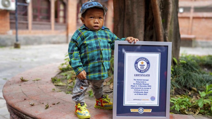 Dor Bahadur Khapangi holds his Guinness World Record certificate in Kathmandu, Nepal, Tuesday, May 24, 2022. Khapangi holds the record as the world's shortest teenager (living), measuring 73.43 cm (2ft 4.9 inches). (AP Photo/Niranjan Shrestha)