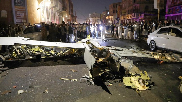 Drone Mata-mata Arab Saudi Ditembak Jatuh di Yaman People gather around the wreckage of a drone aircraft which Houthi rebels claimed to have shot down, in Sanaa, Yemen, Monday, May 23, 2022. (AP Photo/Hani Mohammed)