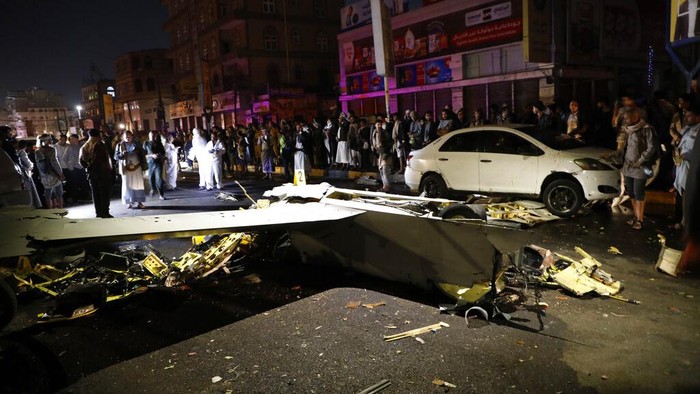 Drone Mata-mata Arab Saudi Ditembak Jatuh di Yaman People gather around the wreckage of a drone aircraft which Houthi rebels claimed to have shot down, in Sanaa, Yemen, Monday, May 23, 2022. (AP Photo/Hani Mohammed)