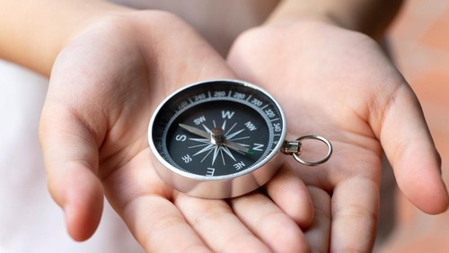 Ilustrasi anak pegang kompas belajar arah mata angin