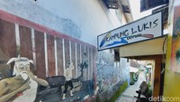 Lokasinya di dalam gang tetapi mata dibuat takjub dengan warna-warni lukisan di tembok dan pagar rumah. Menariknya lagi, lantai kampung ini juga dihiasi batu sikat. Foto: Putu Intan/detikcom