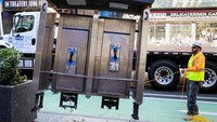 Seorang pekerja mengeluarkan telepon umum terakhir yang ada di dekat Times Square, Kota New York, Senin (23/5/2022) waktu setempat.
