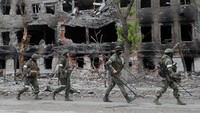 Tentara infanteri Rusia melintas di depan pabrik baja, Azovstal di kota pelabukan Mariupol, Ukraina, 22 Mei 2000. Perang di Ukraina memasuki bulan ketiga dan belum ada tanda-tanda usai. (Alexander Ermochenko/Reuters)