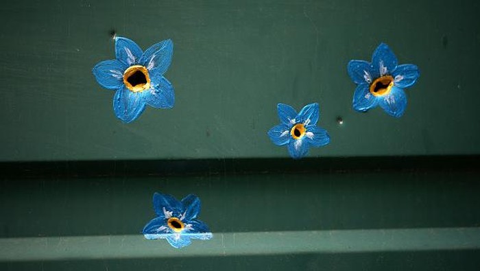 BUCHA, UKRAINE - MAY 23: A butterfly painted around bullet and shrapnel holes by Canadian artist Ivanka Siolkowsky in the war torn suburb of Bucha on May 23, 2022 in Bucha, Ukraine. Silolkowsky is of Ukrainian descent and initially left Toronto at the beginning of the Russian invasion to help with refugees at the Polish border eventually volunteering to help in Bucha. She painted her first flower around a bullet hole after speaking to a resident who said “The bullet holes in my fence remind me of all that I’ve lost