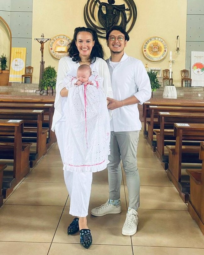 Melalui akun Instagramnya Nadine Chandrawinata tampak membagikan foto-foto ketika anak pertamanya, baby Djiwa dibaptis. Nadine bersama anak dan sang suami, Dimas Anggara tampil kompak dalam balutan busana berwarna putih. Foto: Instagram/@nadinelist