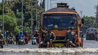 Penampakan sejumlah pekerja pelabuhan yang menumpang truk untuk dapat menerobos banjir limpasan air laut ke daratan atau rob yang merendam kawasan Pelabuhan Tanjung Emas, Semarang, Jawa Tengah.