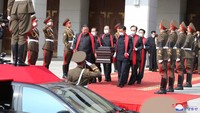Kim terlihat meletakkan tanah di peti mati Hyon dengan tangan kosong alih-alih menggunakan sekop.