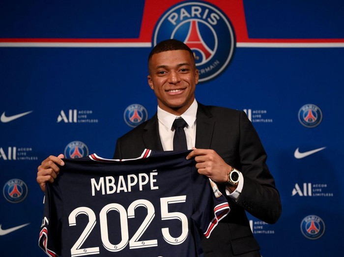 Paris Saint-Germain's French forward Kylian Mbappe poses with a jersey at the end of a press conference at the Parc des Princes stadium in Paris on May 23, 2022, two days after the club won the Ligue 1 title for a record-equalling tenth time and its superstar striker Mbappe chose to sign a new contract until 2025 at PSG rather than join Real Madrid. (Photo by FRANCK FIFE / AFP) (Photo by FRANCK FIFE/AFP via Getty Images)