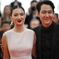 Saat berpose di hadapan ratusan fotografer, Raline Shah sempat bertemu Lee Jung-Jae, aktor Korsel yang namanya mendunia berkat serial Squid Game. Keduanya pun berfoto bersama di karpet merah. (Foto: AFP via Getty Images/LOIC VENANCE)