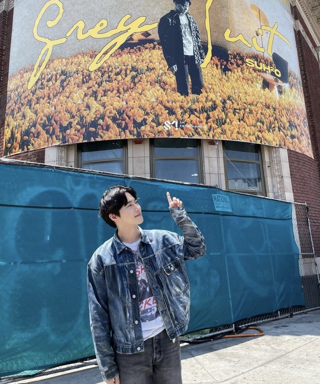 Dari Las Vegas hingga ke Los Angeles. Suho EXO juga berpose di depan papan reklame album barunya ‘Grey Suit’ yang dirilis bulan lalu. Foto: dok. Instagram @kimjuncotton
