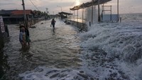 Sejumlah warga berjalan menghindari gelombang air laut di Pesisir pantai Utara, Pekalongan, Jawa Tengah, Senin (23/5/2022). (Harviyan Putra/Antara Foto).
