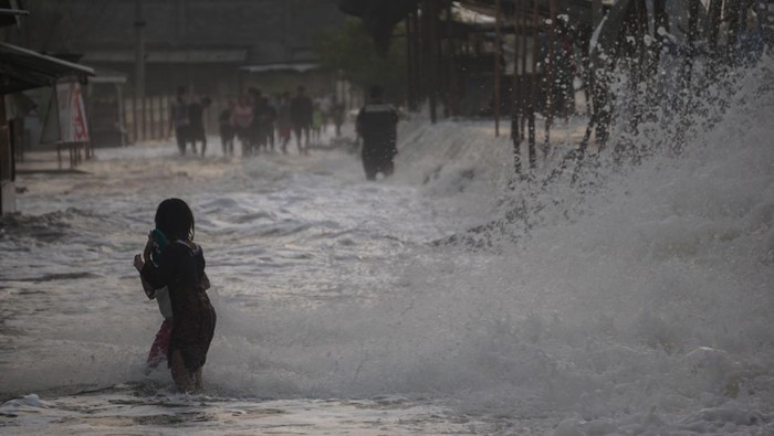 Sejumlah warga berjalan menghindari gelombang air laut di Pesisir pantai Utara, Pekalongan, Jawa Tengah, Senin (23/5/2022). Palang Merah Indonesia (PMI) Kota Pekalongan menghimbau warga sekitar pesisir pantai Utara Pekalongan untuk waspada dengan adanya gelombang laut setinggi sekitar 1-3 meter dan dapat menyebabkan banjir rob. ANTARA FOTO/Harviyan Perdana Putra/rwa.
