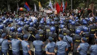 Sejumlah polisi berjaga di area sekitar aksi unjuk rasa menolak klaim kemenangan Ferdinand Bongbong Marcos Jr dan Sara Duterte di Kota Quezon, Metro Manila, Filipina.  