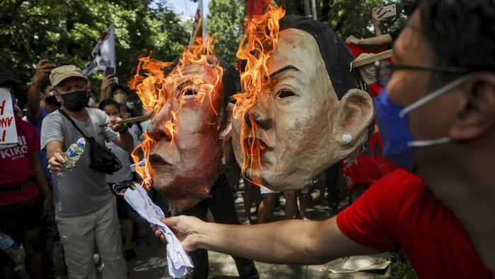 Aksi unjuk rasa menolak kemenangan Ferdinand Marcos Jr digelar di Filipina. Dalam aksi tersebut topeng berbentuk wajah Marcos dibakar masa. Ini fotonya.
