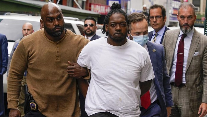 Andrew Abdullah is escorted into the Fifth precinct, Tuesday, May 24, 2022, in New York. Abdullah, the man wanted in an apparently unprovoked fatal shooting aboard a New York City subway train surrendered to police on Tuesday, hours after authorities posted his name and photo on social media and implored the public to help find him. (AP Photo/Mary Altaffer)