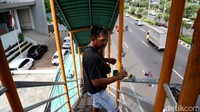 Petugas tampak sedang mengecat ulang pegangan tangga di jembatan penyeberangan orang yang berada di Jalan Ahmad Yani, Kota Bekasi, Jawa Barat.
