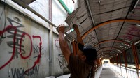 Seorang pekerja melakukan perbaikan jembatan penyeberangan orang di Jalan Ahmad Yani, Kota Bekasi, Jawa Barat, Rabu (25/5/2022).