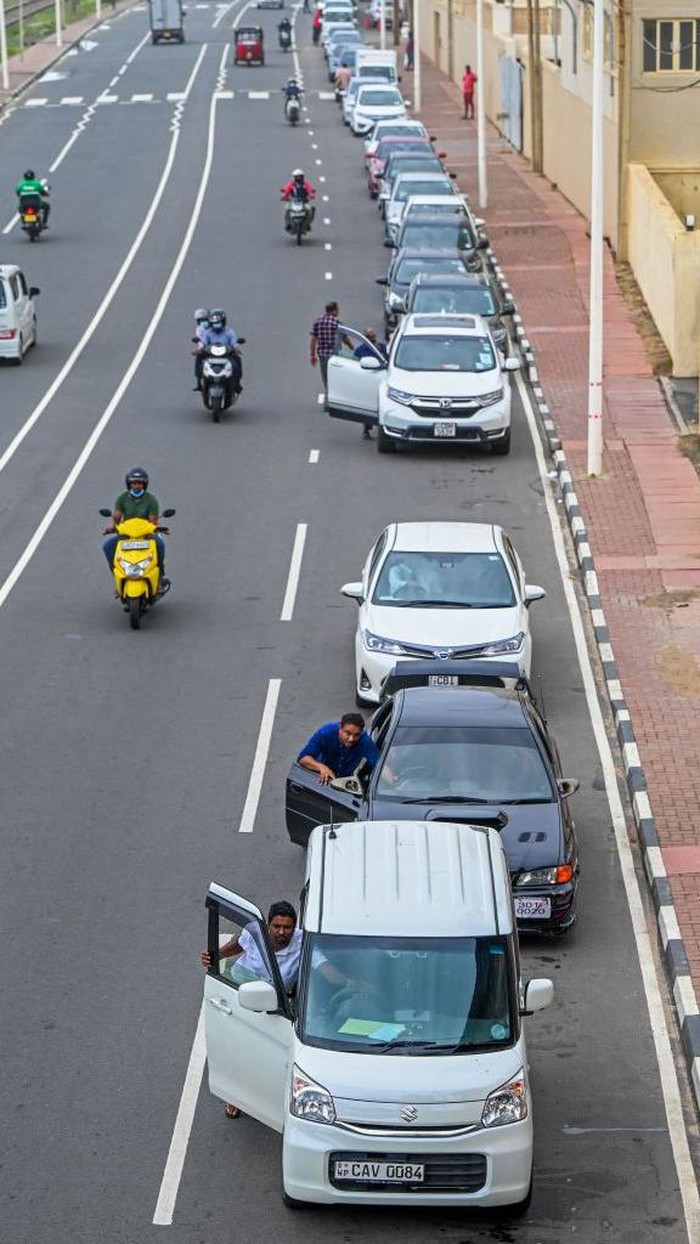 Harga BBM Sri Lanka Naik Capai Rekor Tertinggi, SPBU Dijaga Tentara Motorists queue along a street to buy fuel from Lanka IOC fuel station in Colombo on May 24, 2022. - Cash-strapped Sri Lanka sharply hiked fuel prices to a record high on May 24, causing further pain to the country's 22 million people in its worst crisis since independence. (Photo by Ishara S. KODIKARA / AFP) (Photo by ISHARA S. KODIKARA/AFP via Getty Images)