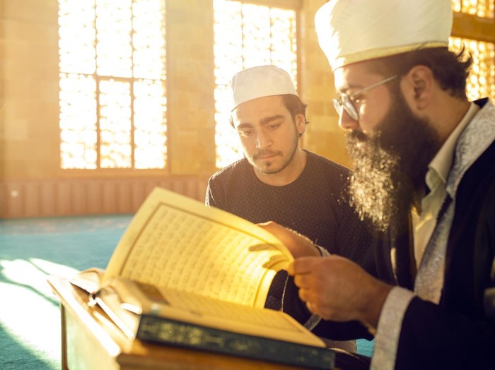 Ilustrasi pria muslim sedang membaca Al-Quran