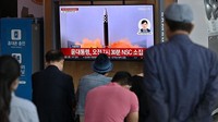 Orang-orang menonton layar televisi yang menayangkan siaran berita dengan rekaman file uji coba rudal Korea Utara, di stasiun kereta api di Seoul, Korea Selatan, Rabu (25/5/2022). (Jung Yeon-Je/Getty Images) 