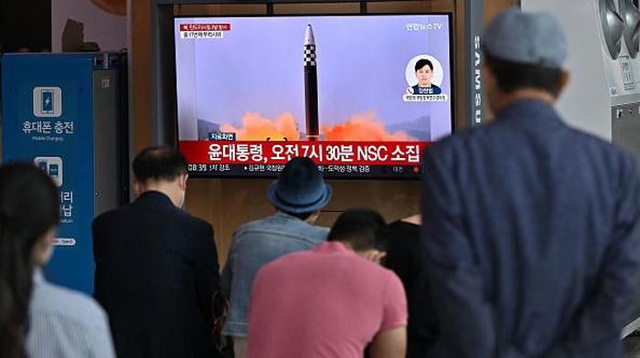 Korut Tembakkan 3 Rudal Usai Biden Tinggalkan Asia People watch a television screen showing a news broadcast with file footage of a North Korean missile test, at a railway station in Seoul on May 25, 2022, after North Korea fired three ballistic missiles towards the Sea of Japan according to South Korea's military. (Photo by JUNG YEON-JE / AFP) (Photo by JUNG YEON-JE/AFP via Getty Images)