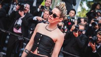 Kristen Stewart melengkapi penampilannya dengan aksesori kaca mata hitam yang menyembunyikan tatapan matanya yang khas. (Foto: WireImage/Samir Hussein)  