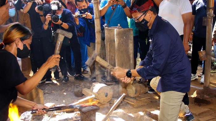 Menteri Pariwisata dan Ekonomi Kreatif (Menparekraf), Sandiaga Salahuddin Uno menempa besi untuk membuat keris saat mengunjungi Desa Wisata Keris Aeng Tongtong, Kecamatan Saronggi, Kabupaten Sumenep, Madura, Jawa Timur, Selasa (24/5/2022).