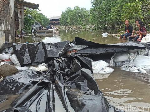 Penampakan tanggul swadaya warga di Sungai Menyong dan banjir rob di Desa Sriwulan, Kecamatan Sayung, Kabupaten Demak, Rabu (25/5/2022) sore.