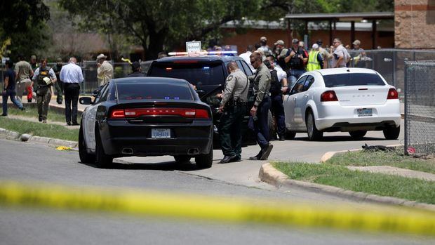 Petugas kepolisian berjaga di lokasi penembakan di dekat Sekolah Dasar Robb di Uvalde, Texas, AS, Selasa (24/5/2022). (REUTERS/Marco Bello)