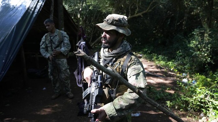 An officer of the Paraguayan SENAD security forces pours out from a sack harvested marijuana into a fire as part of an operation coined New Alliance XXXII in the Maria Auxiliadora Colony of Amambay department in northern Paraguay, Tuesday, May 24, 2022. According to SENAD spokesperson Francisco Vera, 183 hectares of marijuana have been destroyed in the past week, an equivalent of 600 tons, in a joint operation with Brazil’z Federal Police. (AP Photo/Jorge Saenz)
