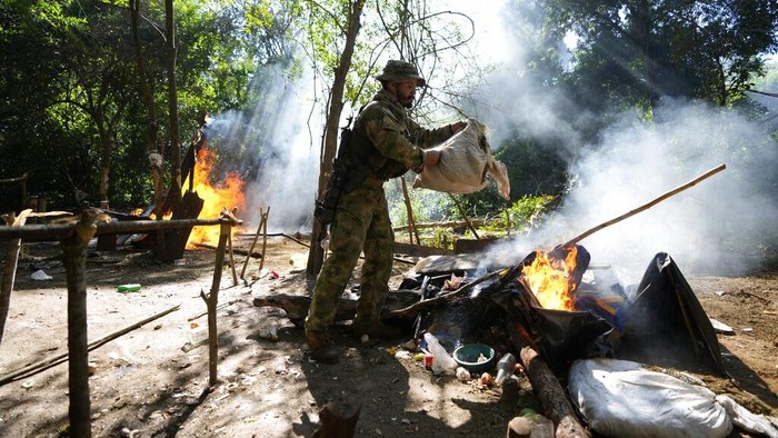 Ratusan Hektar Ladang Ganja di Paraguay Dimusnahkan An officer of the Paraguayan SENAD security forces pours out from a sack harvested marijuana into a fire as part of an operation coined New Alliance XXXII in the Maria Auxiliadora Colony of Amambay department in northern Paraguay, Tuesday, May 24, 2022. According to SENAD spokesperson Francisco Vera, 183 hectares of marijuana have been destroyed in the past week, an equivalent of 600 tons, in a joint operation with Brazilβz Federal Police. (AP Photo/Jorge Saenz)