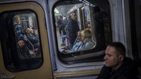 Komuter naik kereta bawah tanah di Kharkiv. Sejak awal invasi Rusia, stasiun metro bawah tanah di kota terbesar kedua di Ukraina itu telah berfungsi sebagai tempat perlindungan bom bagi warga sipil.