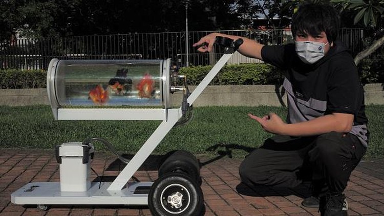 This picture taken on May 19, 2022 showing Jerry Huang walking with his fish tank trolley at a park in Taichung, central Taiwan. (Photo by Sam Yeh / AFP) (Photo by SAM YEH/AFP via Getty Images)