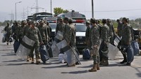 Tak hanya meletakkan kontainer untuk memblokir jalan, sejumlah tentara paramiliter dengan perlengkapan antihuru-hara juga tampak berjaga di sejumlah titik jalan utama ibu kota Islamabad. (AP Photo/Anjum Naveed).  