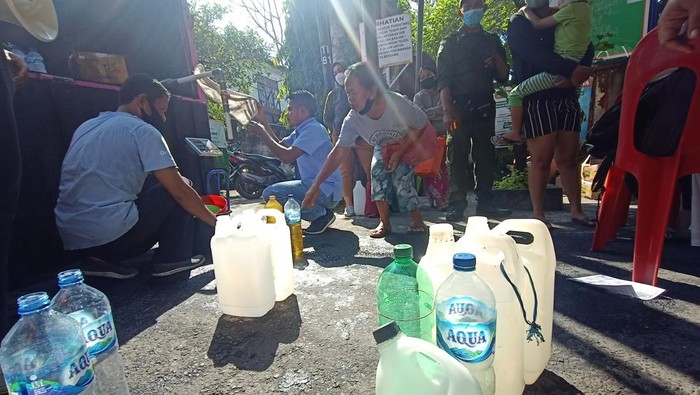 Warga tengah mengantre untuk mendapatkan minyak goreng curah dalam Operasi Pasar Minyak Curah dengan HET di Banjar Tegeh Sari, Kelurahan Tonja, Kota Denpasar, Bali, Minggu (24/4).