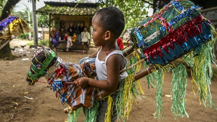 Tiga bocah bermain Kuda Lumping Pandeglang di Desa Ujung Jaya, Pandeglang, Banten, Kamis (26/5/2022). Kuda lumping yang merupakan tarian tradisional tersebut masih dilestarikan di daerah itu agar tidak hilang tergerus arus teknologi yang makin berkembang. ANTARA FOTO/Muhammad Adimaja/YU