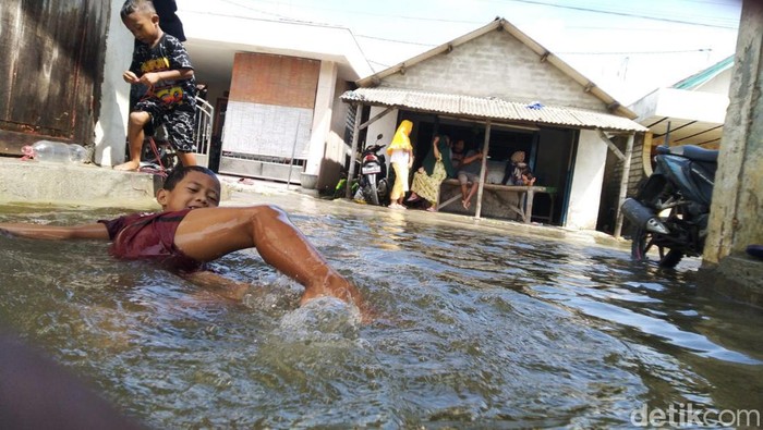 Anak-anak bermain air banjir rob di Gresik