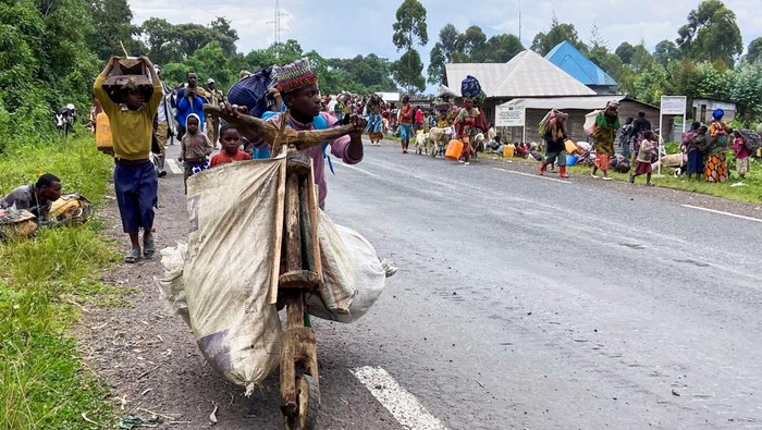 A Congolese civilian pushes a Tshukudu (a wooden bike used for transporting goods) as they flee near the Congolese border with Rwanda after fightings broke out in Kibumba, outside Goma in the North Kivu province of the Democratic Republic of Congo May 24, 2022. REUTERS/Djaffar Sabiti