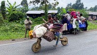 Seorang warga sipil Kongo mendorong Chukudu (sepeda kayu yang digunakan untuk mengangkut barang) saat mereka melarikan diri di dekat perbatasan Kongo dengan Rwanda setelah pertempuran pecah di Kibumba, di luar Goma di provinsi Kivu Utara, Republik Demokratik Kongo 24 Mei 2022.
