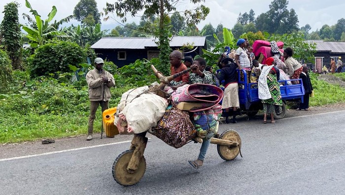 A Congolese civilian pushes a Tshukudu (a wooden bike used for transporting goods) as they flee near the Congolese border with Rwanda after fightings broke out in Kibumba, outside Goma in the North Kivu province of the Democratic Republic of Congo May 24, 2022. REUTERS/Djaffar Sabiti