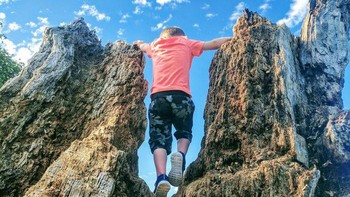 Seorang anak menaiki pohon yang sudah membusuk, tapi terlihat seperti raksasa naik gunung batu. Dok. Brightside
